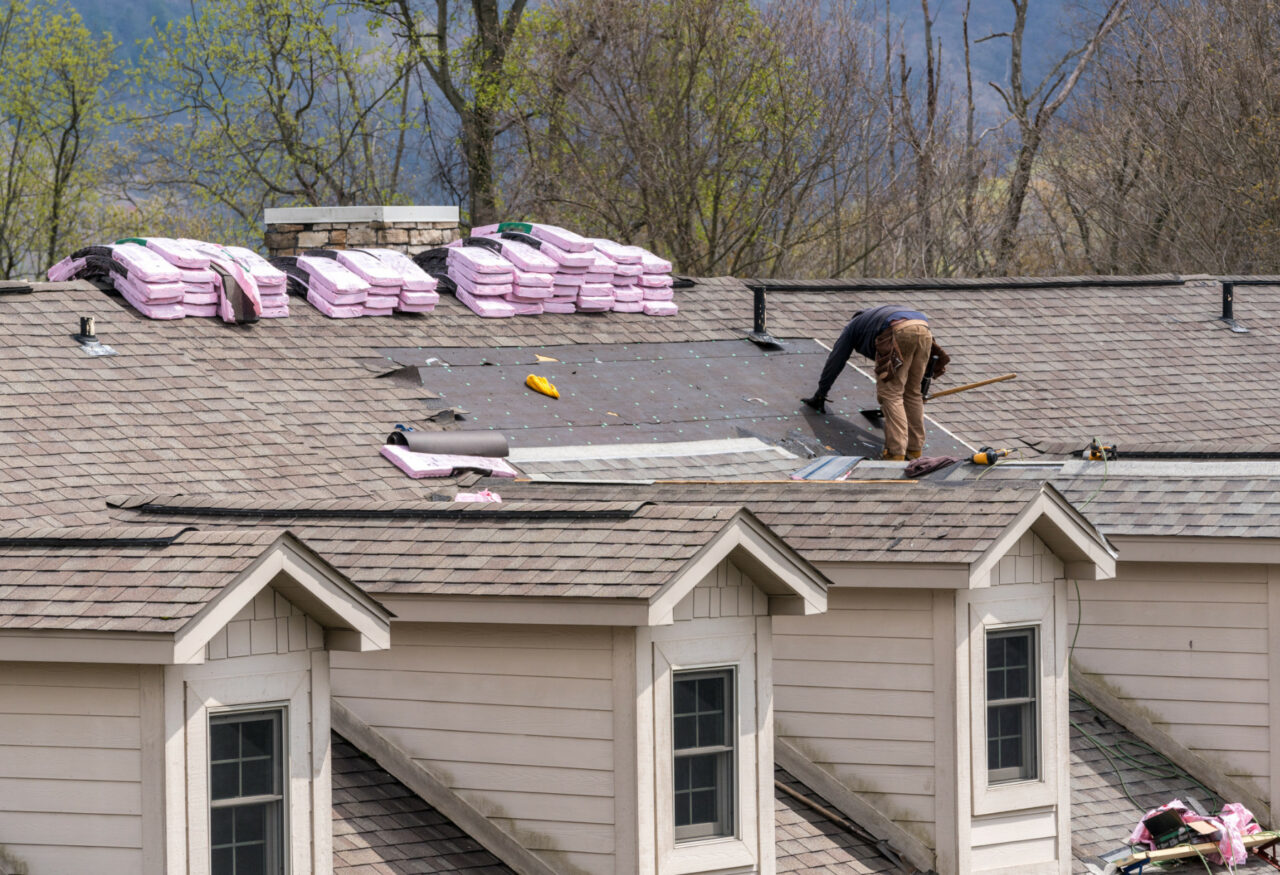 roofing contractor removing old shingles from a townhouse roof